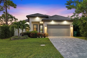 A modern two-story house with a paved driveway and a garage. - New! Coral Tides + Brand 5BR New Luxury Build + Heated Pool + 1 Mile to Vanderbilt Beach! (Naples)