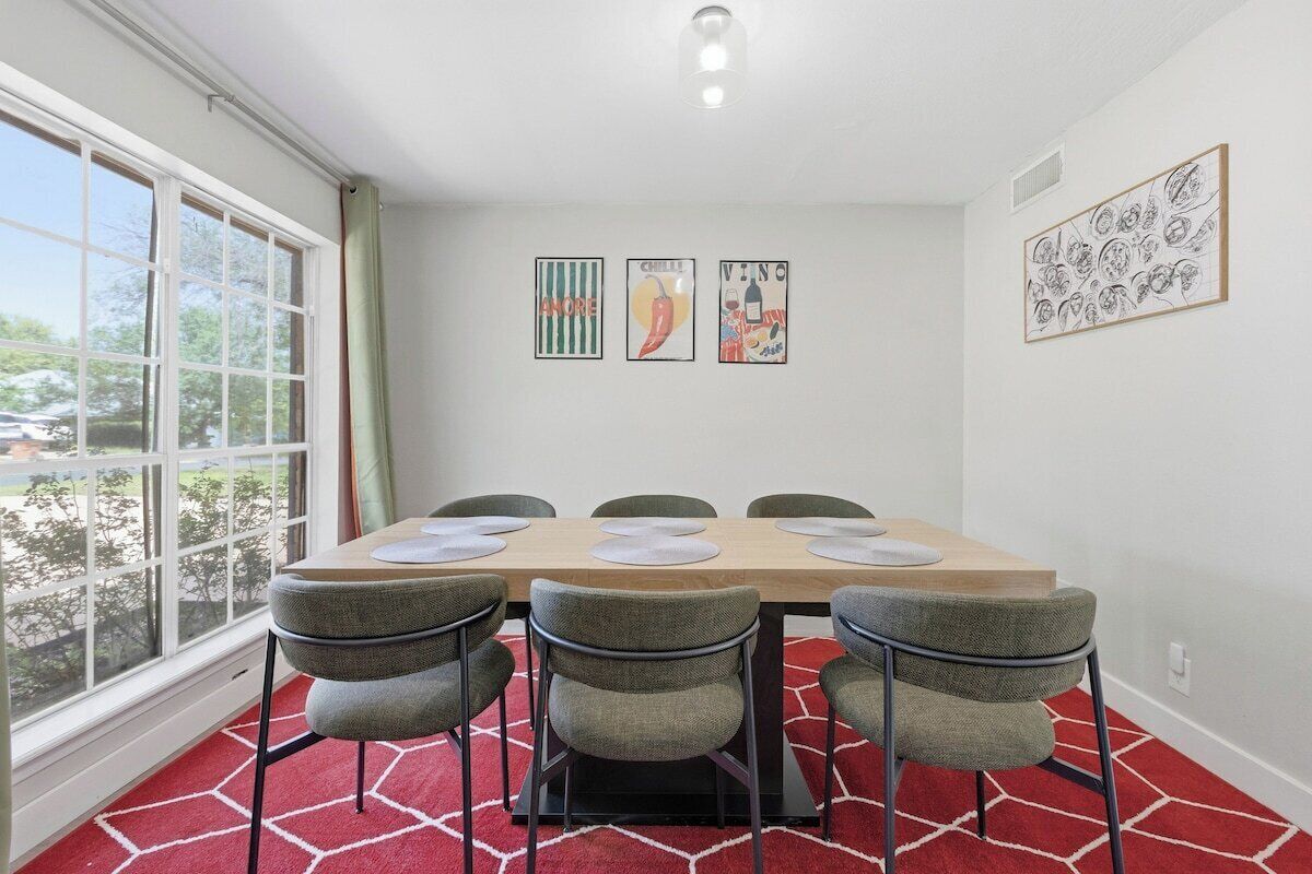 A dining area with a table, chairs, and artwork on the walls.