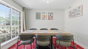 A dining area with a table, chairs, and artwork on the walls.