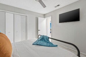 A bedroom with a bed, a television mounted on the wall, and a wardrobe. - Coronado Hills Retreat - Pool + Game Room Fun (Austin)