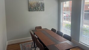 A conference room with a long table, chairs, a rug, and a painting on the wall. - Beautiful Condo with newly appliances, bedroom sets located at the East Downtown (Houston)