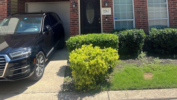 A two-story brick house with a garage, a black car parked in the driveway, and a well-maintained lawn. - Beautiful Condo with newly appliances, bedroom sets located at the East Downtown (Houston)