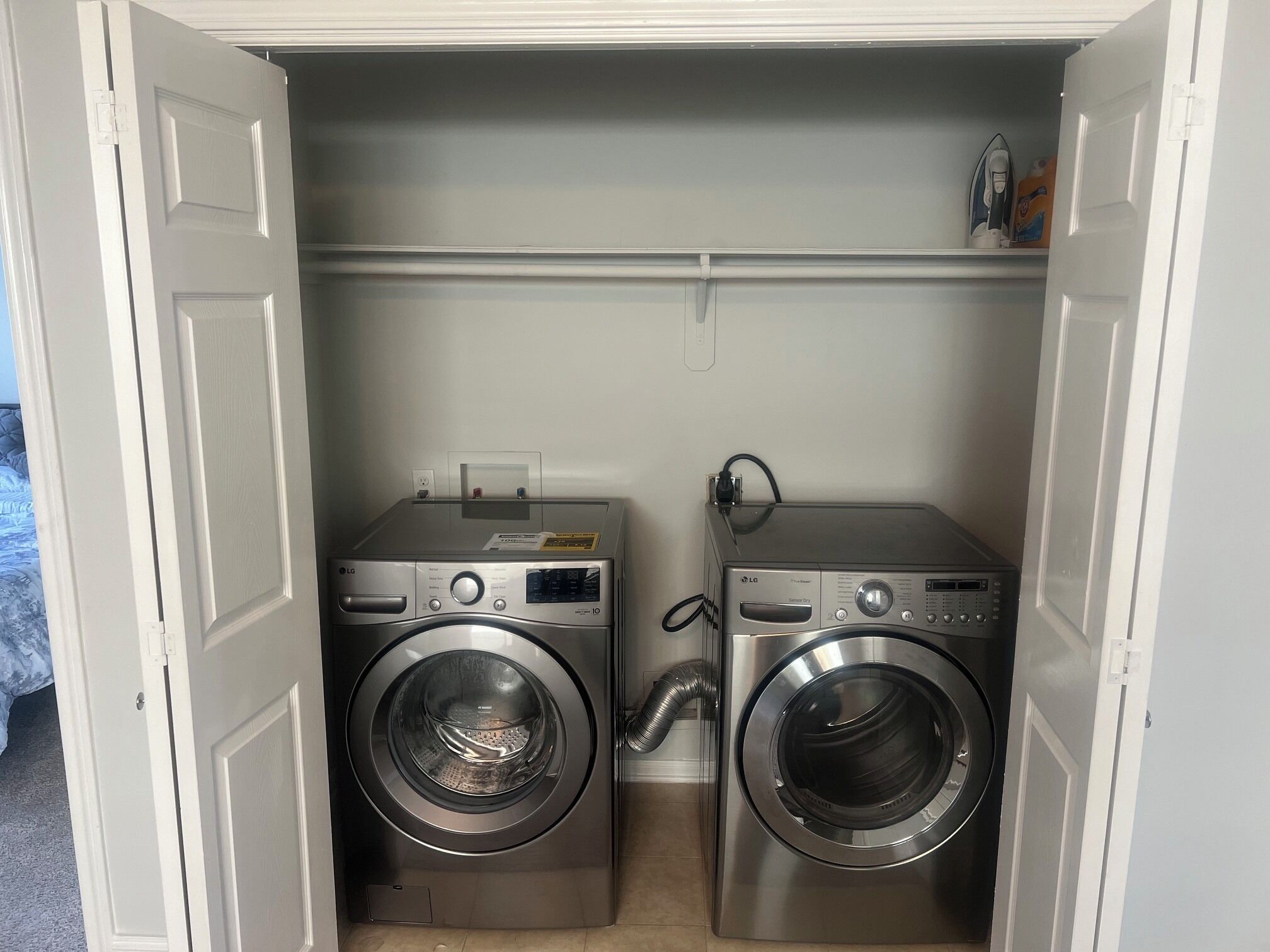 A laundry room with two front-loading LG washing machines and a dryer.