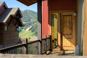 Eine Holzhütte mit Balkon und Blick auf eine Berglandschaft.