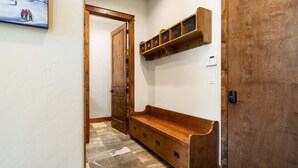 A hallway with a wooden bench, a door, and a wall-mounted shelf. - Winter Park Resort Villa 509 I Hot Tub I Great View I Theatre I Fire Table I Discounted Attractions (Winter Park)