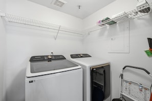 Une buanderie équipée de deux machines à laver, d’un étendoir et d’un chariot utilitaire.
