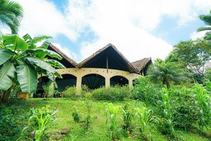A building with a traditional architectural style, featuring a central courtyard and a sloped roof. - Arenal Rainforest (La Fortuna)