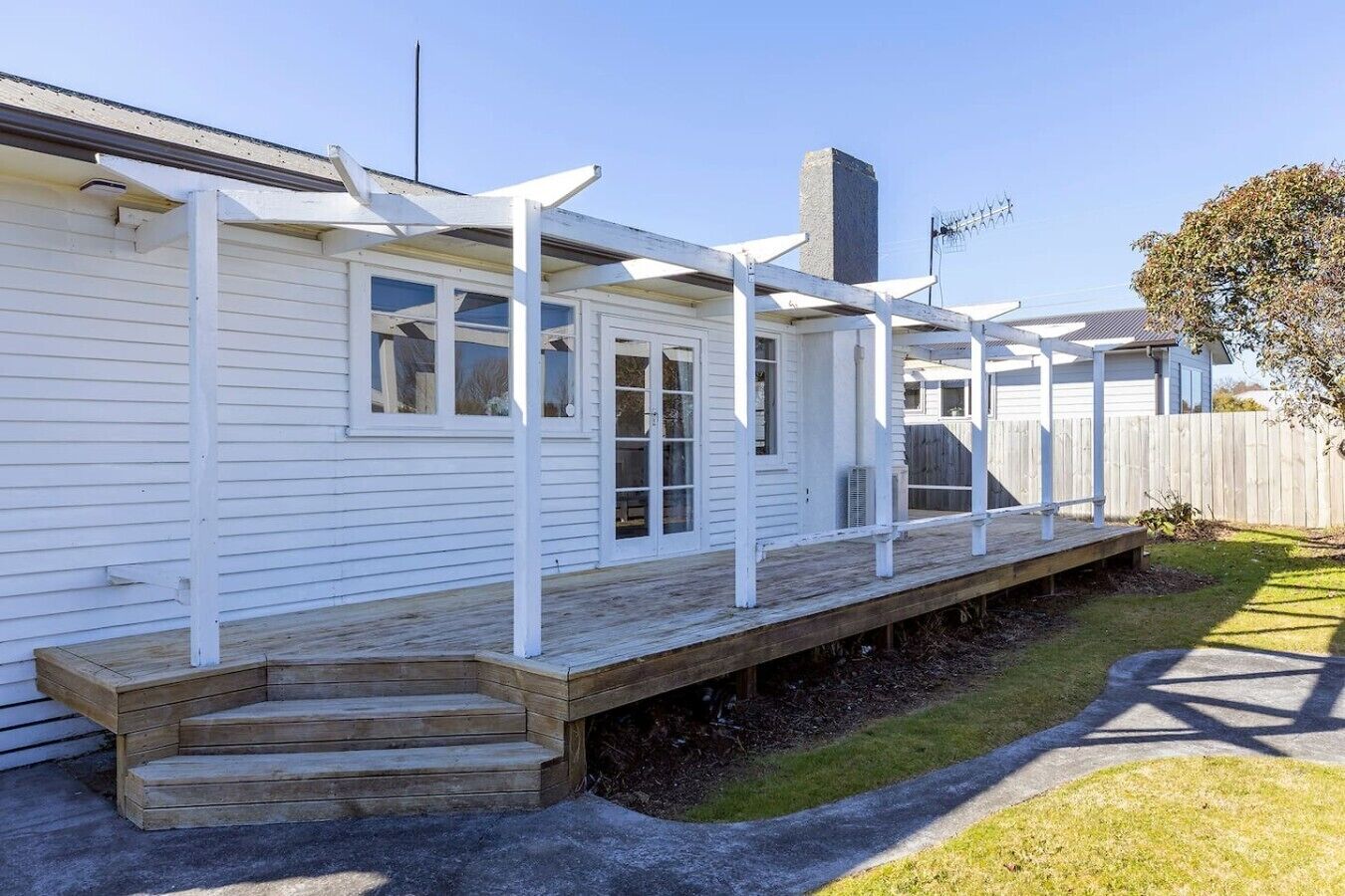 A single-story house with a covered porch and a small set of steps leading to the entrance.