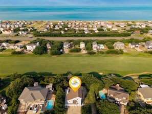 An aerial view of a coastal residential area with houses, a golf course, and a large body of water. - Litts Go Play-Soundside retreat with 4 bedrooms, deck, and ocean views. (Kitty Hawk)