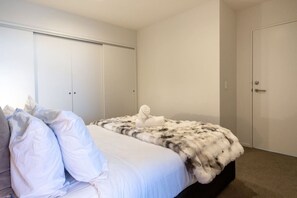 A bedroom with a bed, a wardrobe, and a door. - Heart of CBD - Walk to ONE NZ Stadium + Parking (Christchurch)