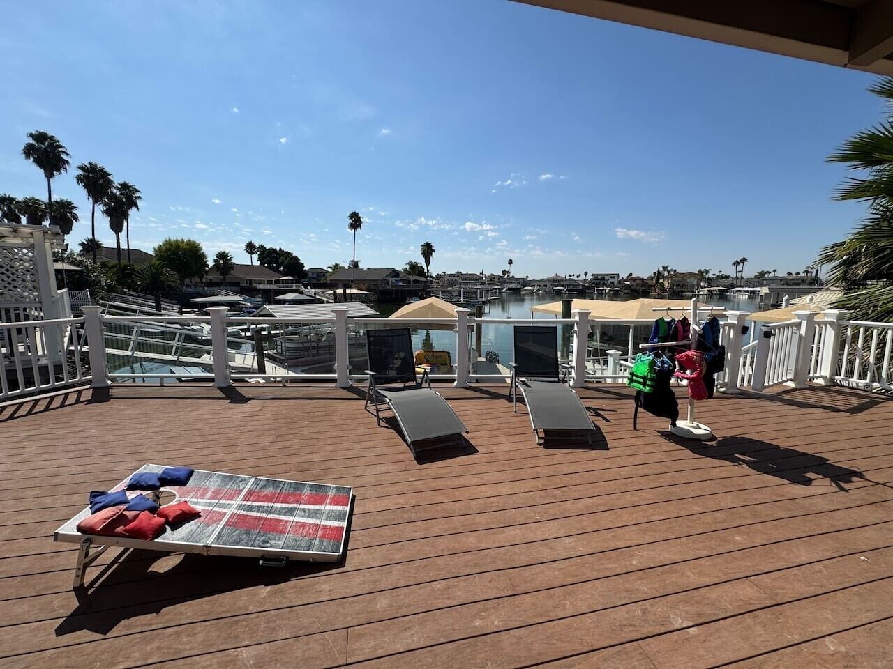 A sun deck with lounge chairs, a table with cushions, and a clothing rack.