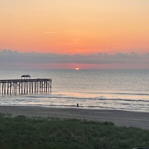 A pier extending into calm waters with a sunset in the background. - Blue Heron Laguna Haven 253-West End-Sleeps 12 (Panama City Beach)