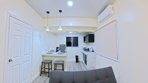 A compact living space with a kitchenette, a dining area, and a seating area.