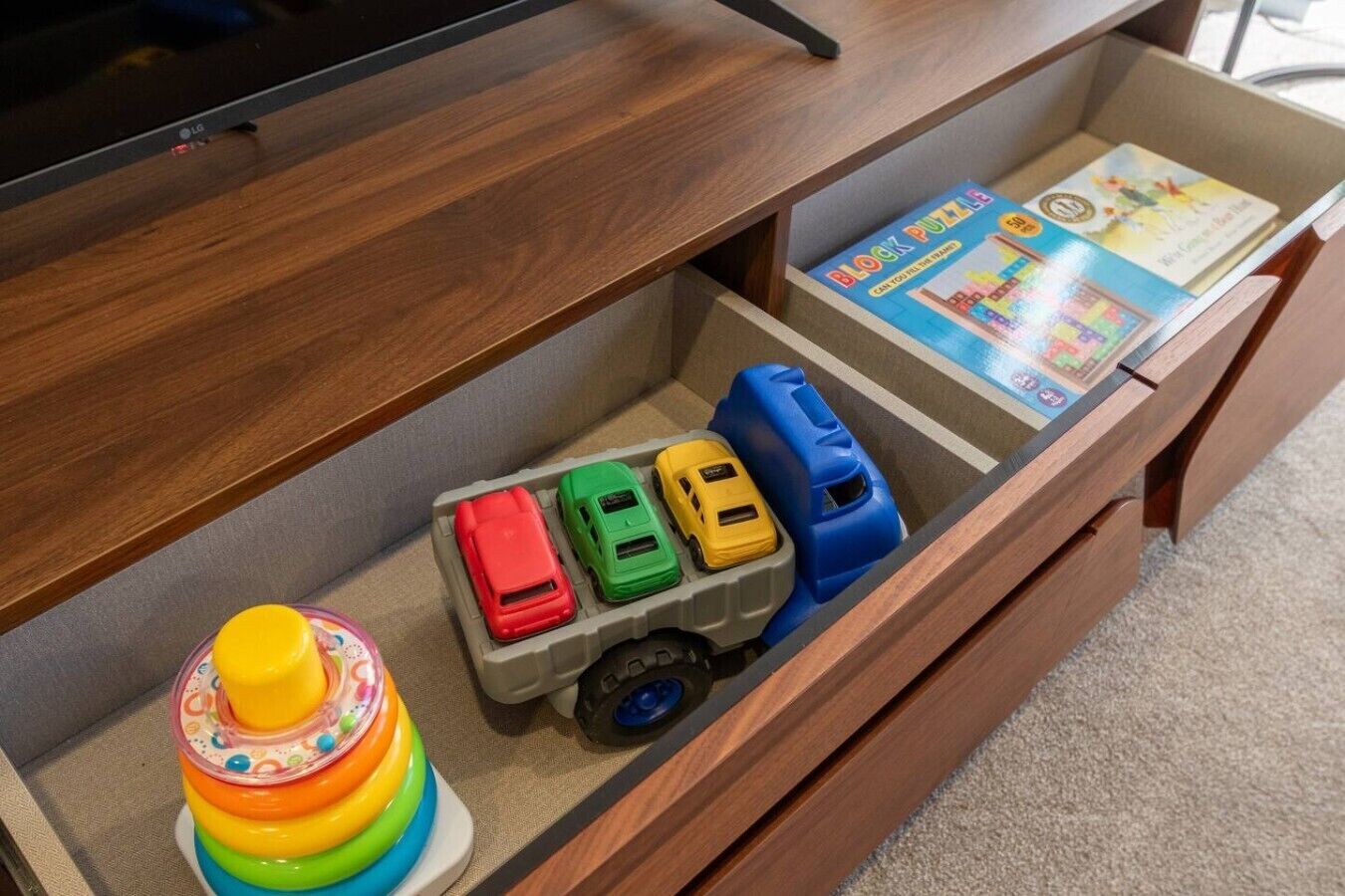 A wooden cabinet with a toy truck and a children's toy.