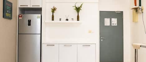 Una cocina moderna con refrigerador empotrado, aire acondicionado de pared y una puerta con panel de mantenimiento.