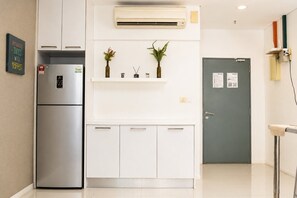 Et moderne køkken med indbygget køleskab, vægmonteret klimaanlæg og en dør med en servicelåge.