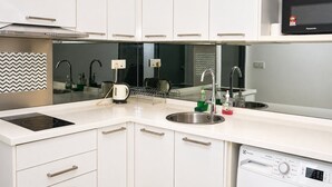Una cocina moderna con armarios blancos, electrodomésticos de acero inoxidable y lavavajillas integrado.