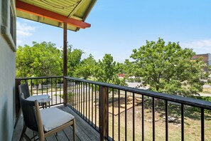 Ein Balkon mit Blick auf Bäume und eine Straße.