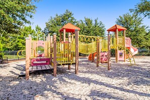 Ein Spielplatz mit Klettergerüsten, Rutschen und einem Sandkasten.