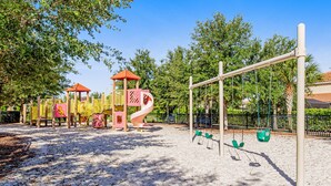 Ein Spielplatz mit Rutsche, Schaukeln und Klettergerüsten.