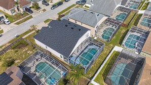 Vista aérea de uma área residencial com várias casas, cada uma com piscina.
