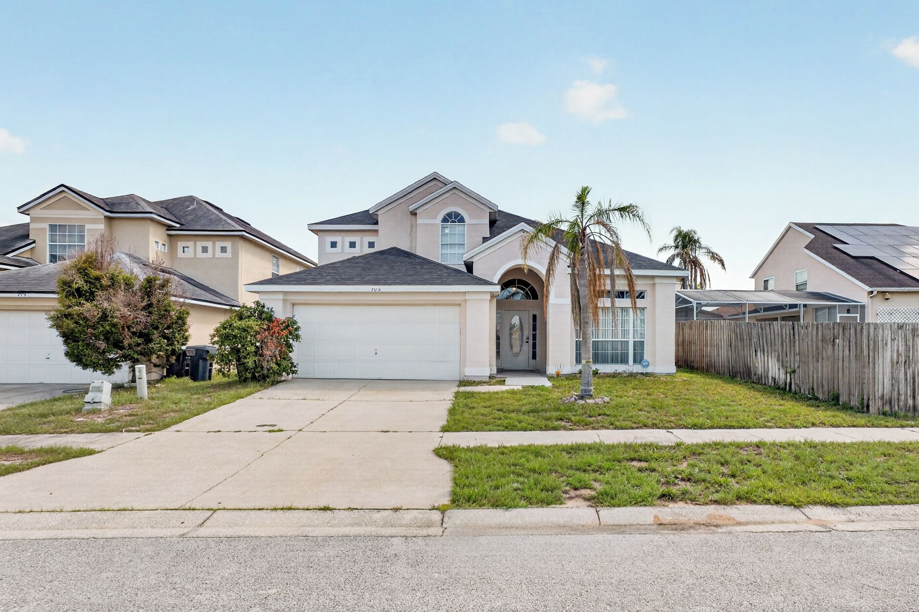 A residential area with houses, a driveway, and a sidewalk.