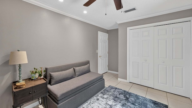 A bedroom with a bed, bedside table, lamp, and a ceiling fan. - Kis105-2601-4-pg - Shingle Creek Poolside Retreat (Kissimmee)