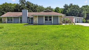 A two-story house with a stone facade, a garage, and a well-maintained lawn. - Kis105-2601-4-pg - Shingle Creek Poolside Retreat (Kissimmee)