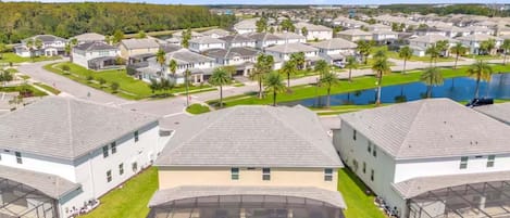 A residential area with multiple houses, a swimming pool, and a clear sky.