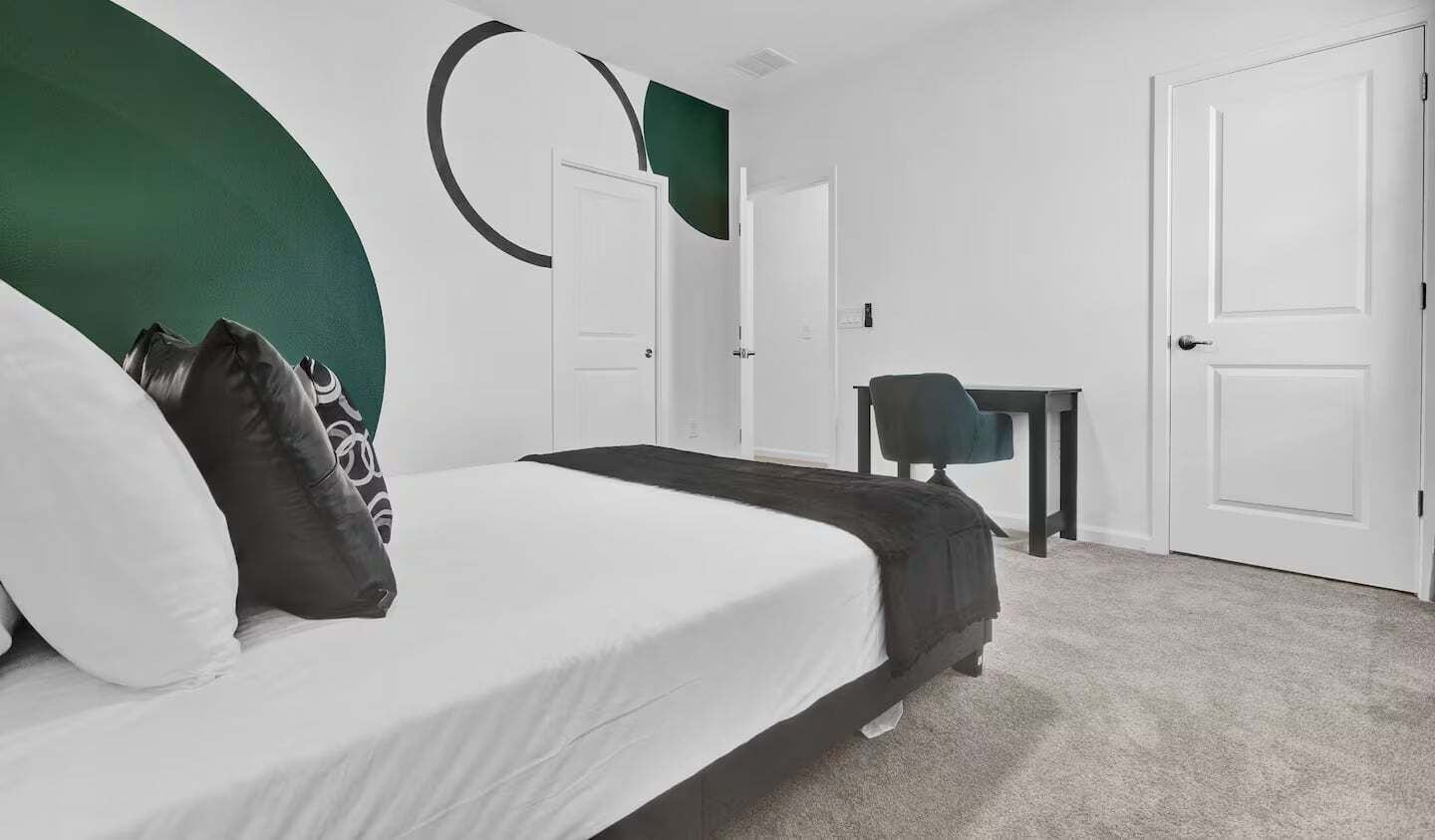 Een slaapkamer met een bed, een bureau en twee deuren.
