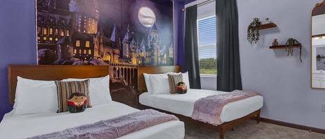 Une chambre d’hôtel avec deux lits, une grande fresque représentant un paysage urbain, une fenêtre avec des rideaux et un miroir sur le mur.