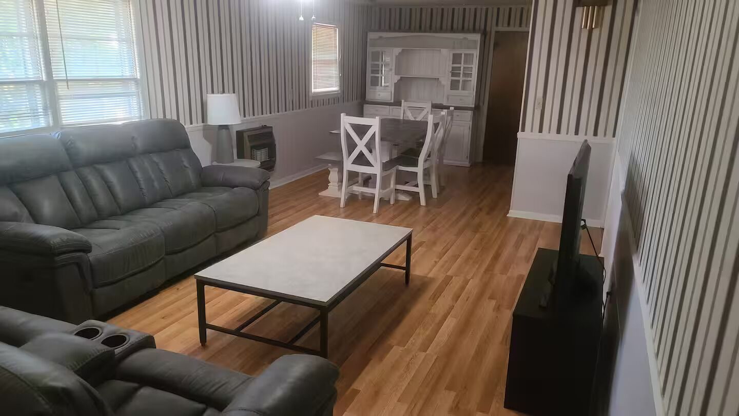 A living room with a sofa, a coffee table, and a TV stand.