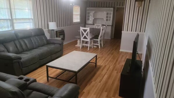 A living room with a sofa, a coffee table, and a TV stand.