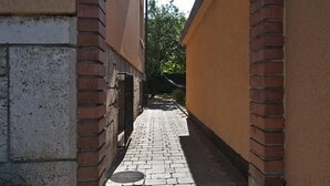 A narrow alleyway with a brick archway leading to a building.
