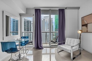 A modern apartment with a balcony, a dining table with chairs, a sofa, and a floor lamp. - Resort on Miami River for 2 (Miami)
