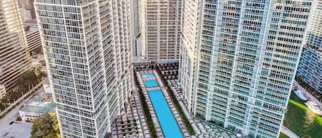 Un edificio alto con un patio central que tiene una piscina.