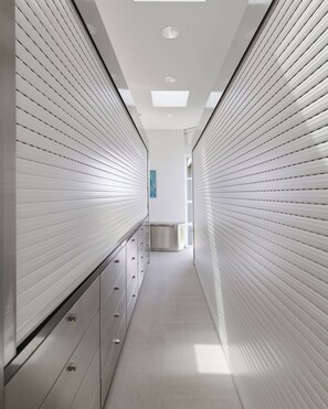A corridor with a modern design, featuring a series of cabinets on one side and a patterned wall on the other. - Art • Architecture • A Living Masterpiece on the Hilltop of Manhattan Beach (Manhattan Beach)