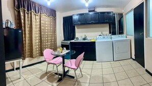 A compact kitchen with a dining area, including a table with chairs, a refrigerator, a stove, and a washing machine. - Estudiocentrico Loft, Tijuana, BC (Tijuana)