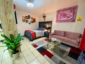 A room with a bed, a sofa, a coffee table, and a potted plant. - Estudiocentrico Loft, Tijuana, BC (Tijuana)