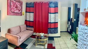 A living room with a sofa, a glass coffee table, and patterned curtains. - Estudiocentrico Loft, Tijuana, BC (Tijuana)