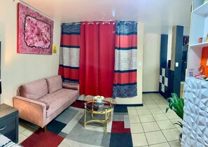 A living room with a sofa, a glass coffee table, and patterned curtains. - Estudiocentrico Loft, Tijuana, BC (Tijuana)