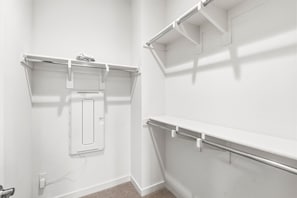 Ein heller Innenraum mit Einbauschränken, einer Steckdose und einem Lüftungsgitter an der Wand.