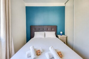 Ein Hotelzimmer mit einem Bett, einem Nachttisch und einer blauen Wand.