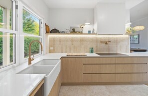 Eine moderne Küche mit großem Fenster, einer Spüle und einer Arbeitsplatte.