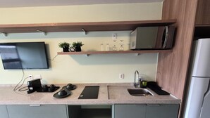 Eine moderne Küche mit Flachbildfernseher, Mikrowelle und Kühlschrank.