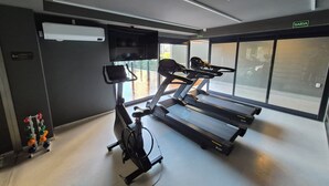 Ein Fitnessraum mit Laufbändern, einem Ergometer und einem Rudergerät.