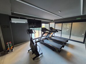 Ein Fitnessraum mit Laufbändern, einem Ergometer und einem Rudergerät.