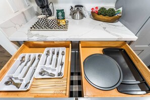 Eine Küchenarbeitsfläche mit Kaffeemaschine, Wasserkocher und einer Schüssel mit grünen Blättern.