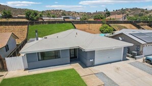 A residential building with a garage, a covered patio, and a fenced yard. - Spacious 4-bedroom house in tranquil Lakeside with AC (Lakeside)
