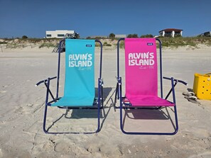 Two beach chairs with 'Alvin's Island' branding on a sandy beach. - Waterfront views • Walk to Beach • Riverfront pool • Dog-friendly (St. Augustine)